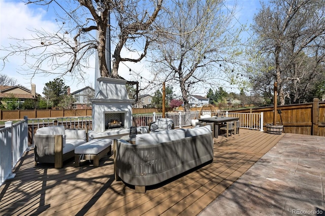 deck with a fenced backyard and an outdoor living space with a fireplace