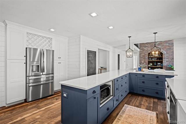 kitchen featuring stainless steel appliances, dark wood-style flooring, white cabinetry, pendant lighting, and light countertops