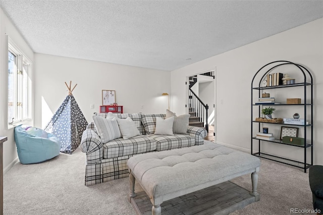carpeted living area featuring stairs and a textured ceiling
