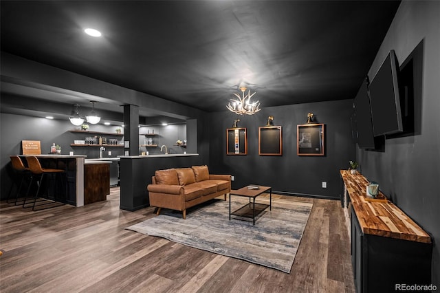 living room featuring wood finished floors, bar area, recessed lighting, and a chandelier