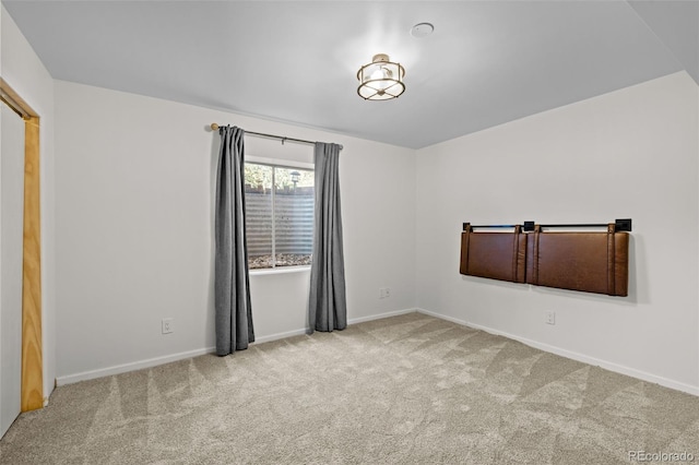 carpeted empty room featuring baseboards