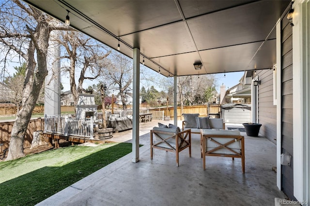 view of patio / terrace with an outdoor living space with a fireplace and fence