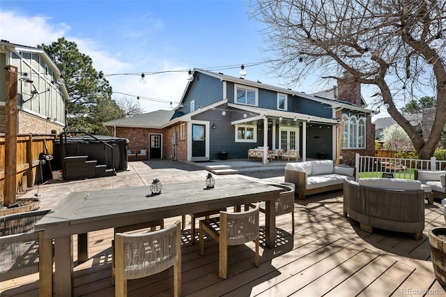 deck with outdoor lounge area, a hot tub, a fenced backyard, and outdoor dining area