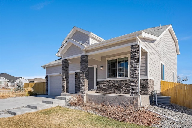 view of front of home featuring a porch, a garage, and central air condition unit