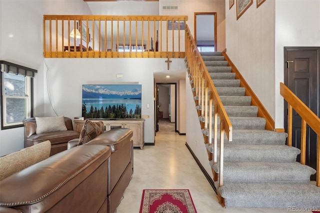 stairway featuring concrete floors and a high ceiling