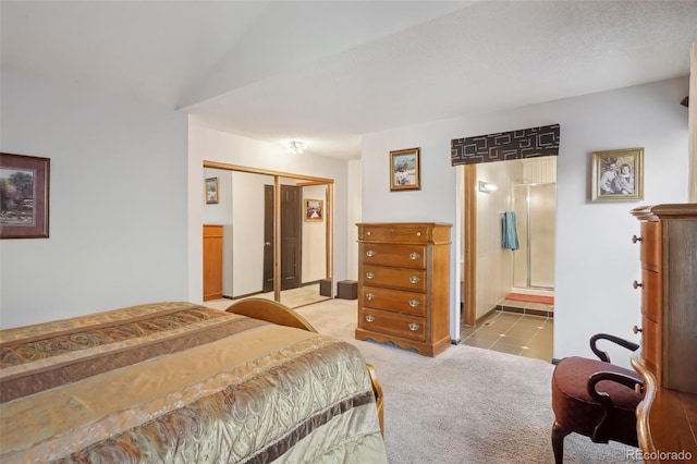 bedroom with connected bathroom, a closet, and light colored carpet