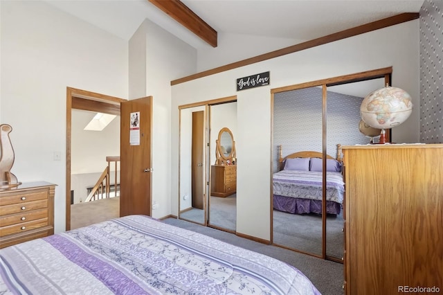 carpeted bedroom featuring vaulted ceiling and two closets