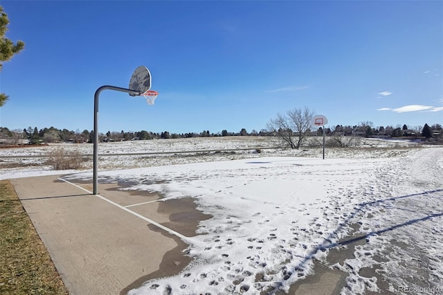 yard layered in snow featuring basketball hoop