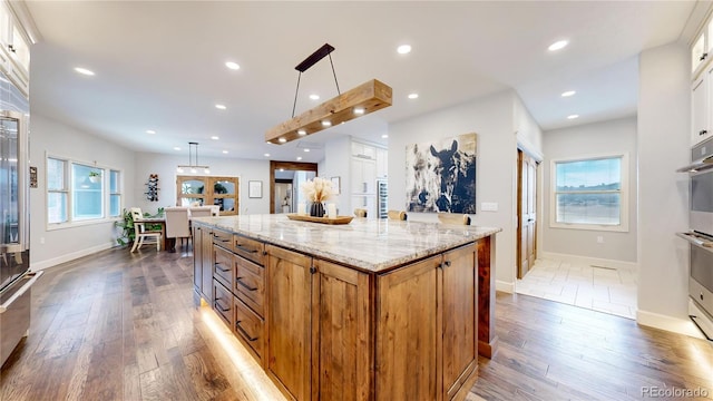 kitchen with white cabinets, pendant lighting, and a kitchen island