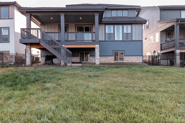 2967 S Quaker St, Morrison, CO 80465 - back of property featuring board and batten siding, a fenced backyard, stone siding, and stairway