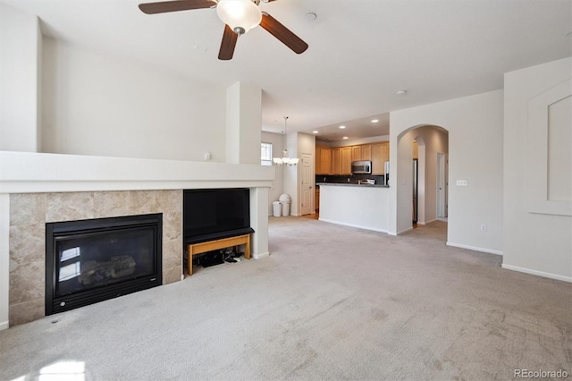 14197 W 84th Cir Unit C, Arvada, CO 80005 - unfurnished living room with a ceiling fan, light colored carpet, arched walkways, recessed lighting, and a tiled fireplace