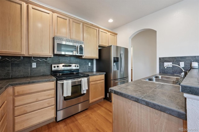 14197 W 84th Cir Unit C, Arvada, CO 80005 - kitchen with appliances with stainless steel finishes, light brown cabinets, arched walkways, recessed lighting, and light wood-style floors