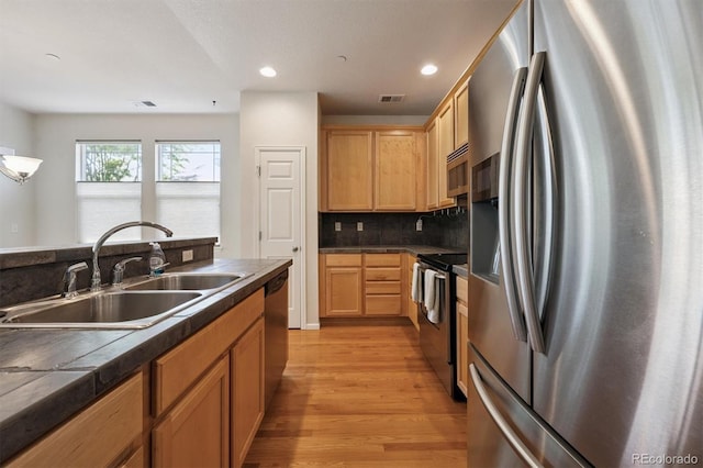 14197 W 84th Cir Unit C, Arvada, CO 80005 - kitchen with appliances with stainless steel finishes, light wood-type flooring, dark countertops, recessed lighting, and decorative backsplash