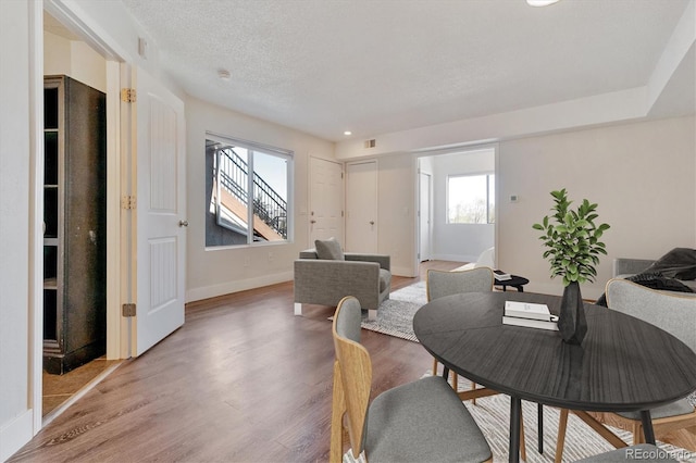 1820 Newland Ct Unit 210, Lakewood, CO 80214 - dining space featuring light wood-style flooring, baseboards, and a textured ceiling