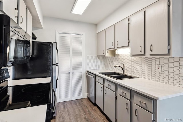 1820 Newland Ct Unit 210, Lakewood, CO 80214 - kitchen with black appliances, a sink, gray cabinetry, wood finished floors, and tasteful backsplash