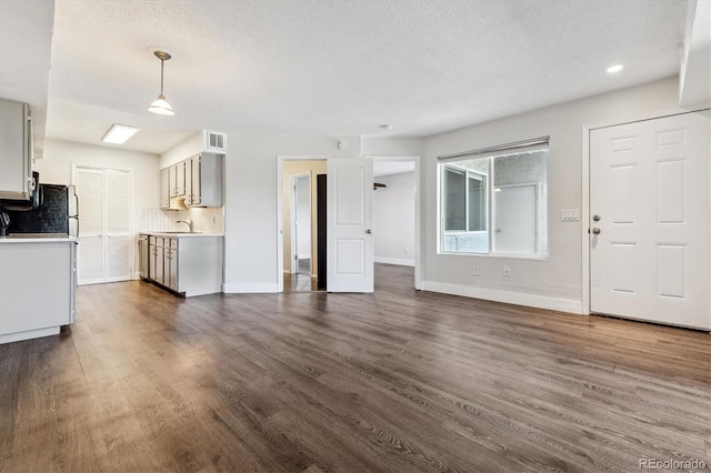 1820 Newland Ct Unit 210, Lakewood, CO 80214 - unfurnished living room with a sink, dark wood-style floors, a textured ceiling, baseboards, and recessed lighting