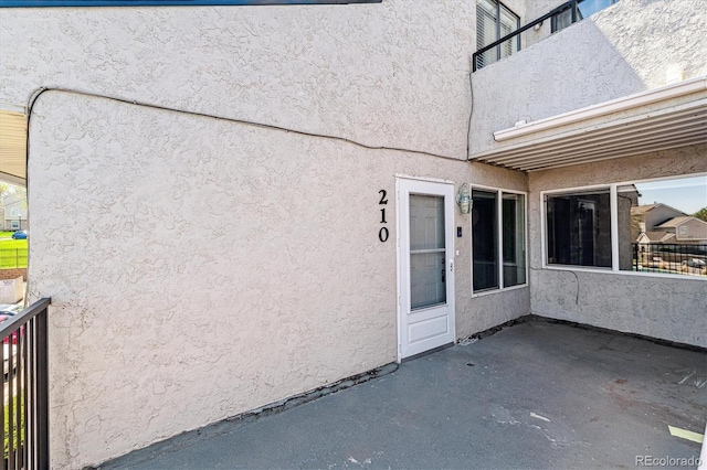 1820 Newland Ct Unit 210, Lakewood, CO 80214 - doorway to property with a patio area, stucco siding, and a balcony