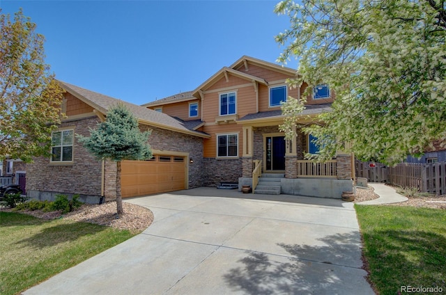 craftsman-style house with concrete driveway, an attached garage, fence, and stone siding
