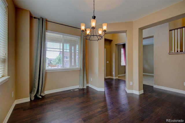 unfurnished dining area featuring baseboards, visible vents, dark wood-style flooring, and a notable chandelier