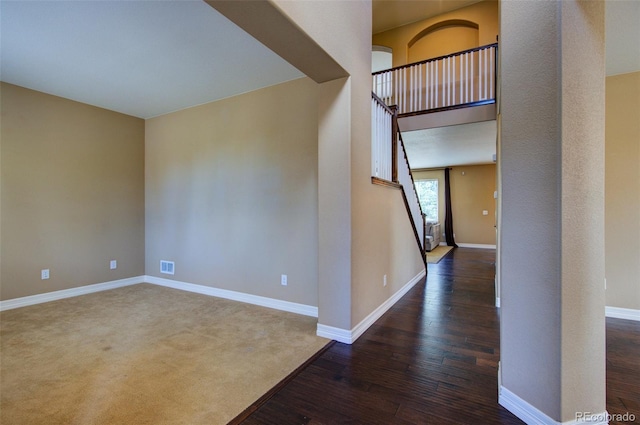 interior space with baseboards, visible vents, and wood finished floors