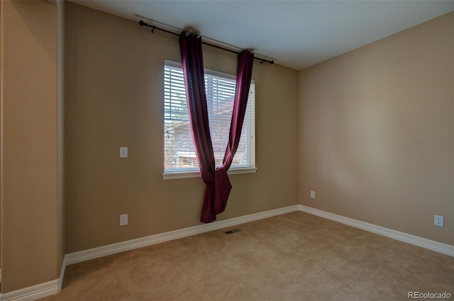 empty room featuring carpet flooring, baseboards, and visible vents