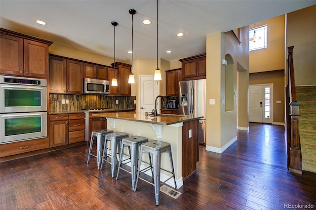 kitchen featuring tasteful backsplash, a kitchen breakfast bar, a wealth of natural light, and stainless steel appliances