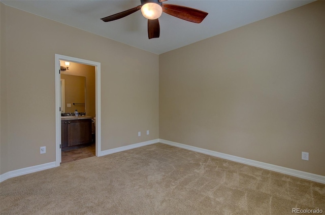 spare room featuring baseboards, a ceiling fan, and light colored carpet
