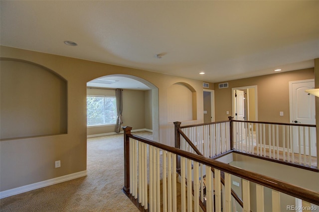 hallway with visible vents, light carpet, baseboards, recessed lighting, and an upstairs landing