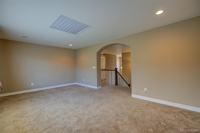 unfurnished room featuring arched walkways, baseboards, light carpet, and recessed lighting