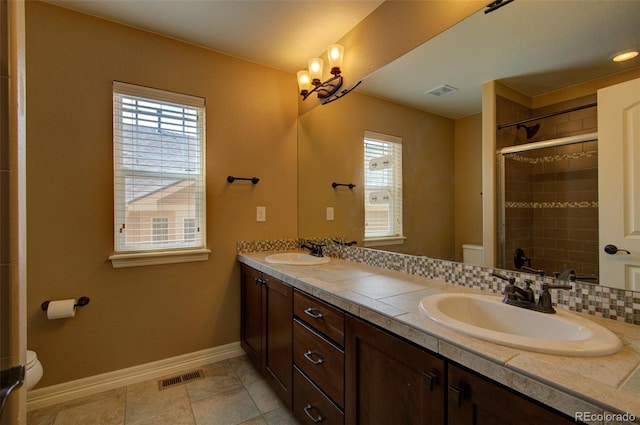 full bathroom with visible vents, a sink, a healthy amount of sunlight, and toilet