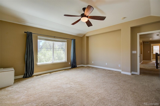 empty room featuring baseboards, ceiling fan, carpet, and vaulted ceiling