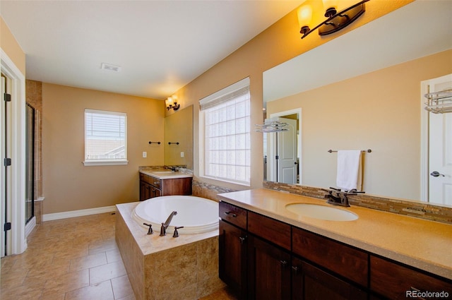 full bath with visible vents, a sink, a wealth of natural light, and a bath