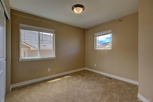 empty room with baseboards and carpet