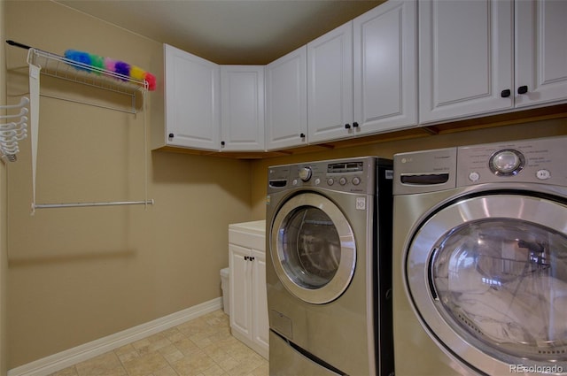 laundry area featuring baseboards, cabinet space, and washer and dryer