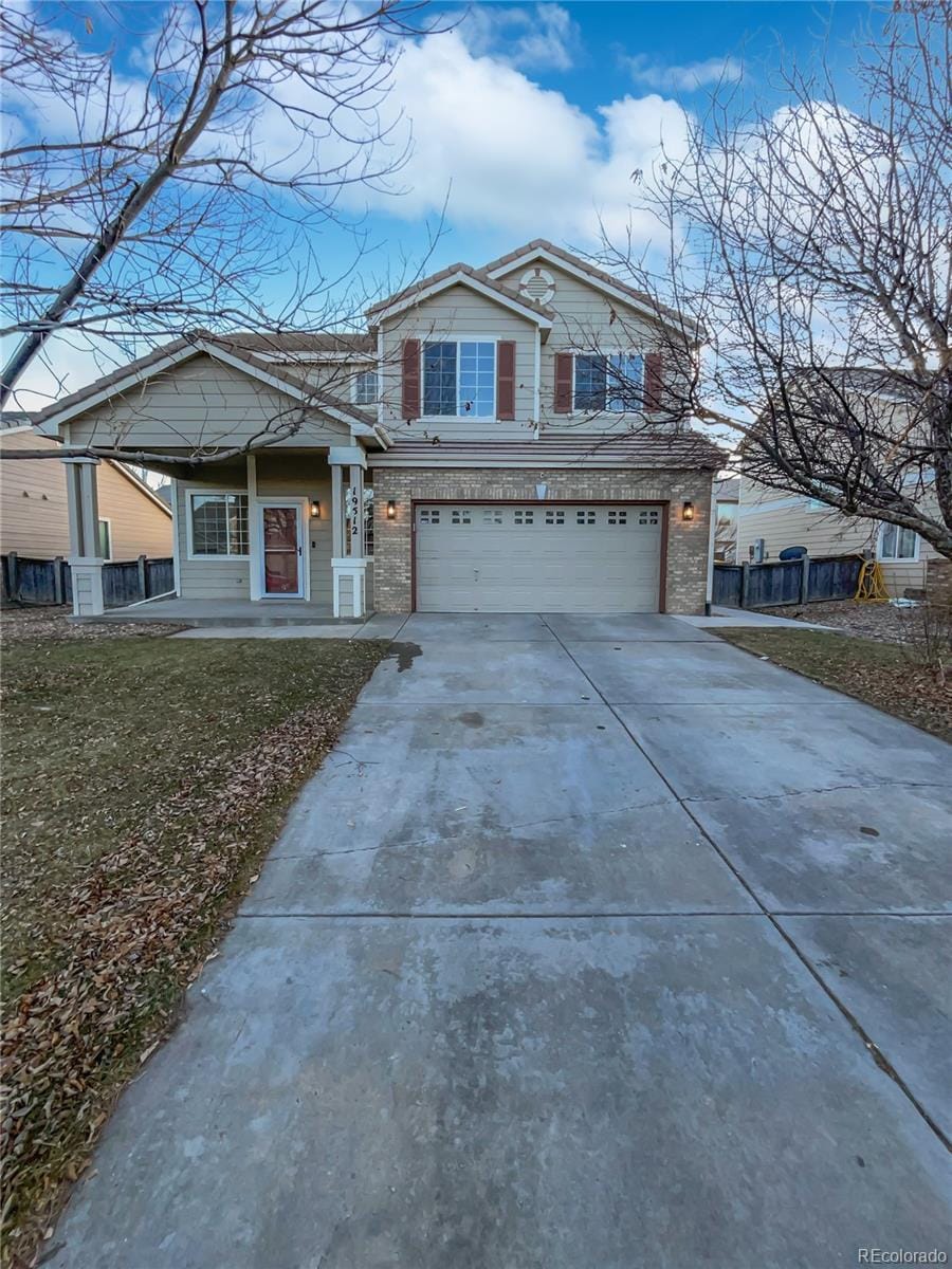 19512 E 58th Dr, Aurora, CO 80019 - view of front facade with a garage, a porch, and a front yard