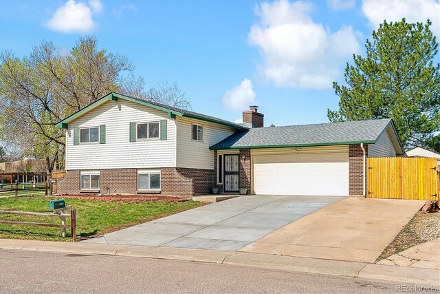 7158 W Roxbury Ave, Littleton, CO 80128 - split level home with driveway, a chimney, fence, a garage, and brick siding