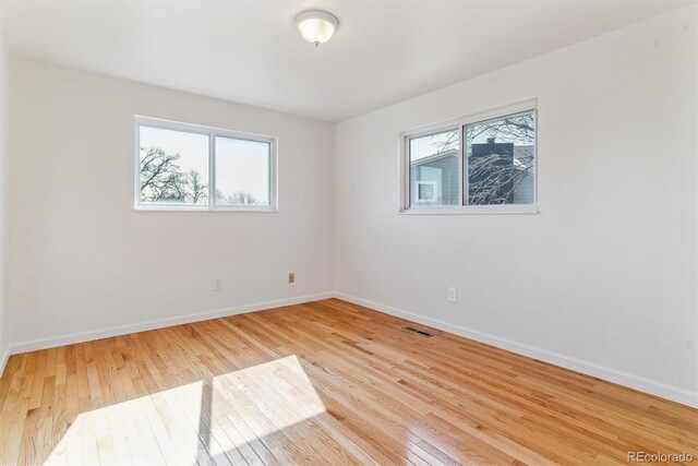 7158 W Roxbury Ave, Littleton, CO 80128 - unfurnished room with wood finished floors, visible vents, and baseboards