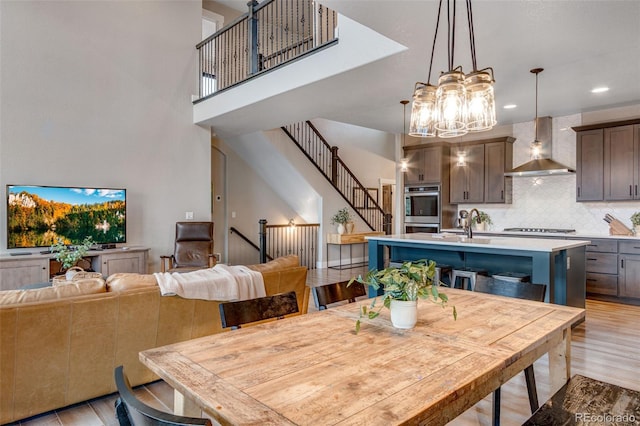 6093 Carmon Dr, Windsor, CO 80550 - dining room with recessed lighting, light wood-style flooring, a notable chandelier, and stairway
