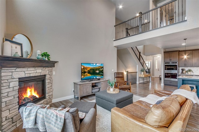 6093 Carmon Dr, Windsor, CO 80550 - living area featuring a towering ceiling, baseboards, stairway, and light wood-style floors