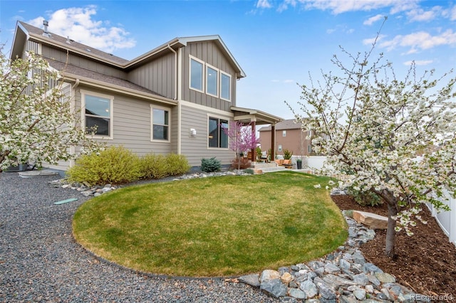 6093 Carmon Dr, Windsor, CO 80550 - back of house featuring board and batten siding and a yard