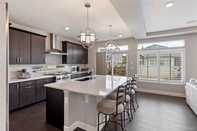 4504 N Picadilly Ct, Aurora, CO 80019 - kitchen featuring wall chimney exhaust hood, stainless steel gas stove, dark wood-type flooring, a chandelier, and recessed lighting