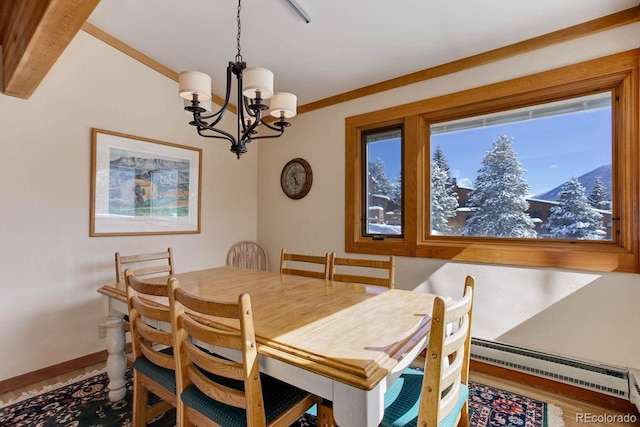 dining room featuring a notable chandelier, baseboard heating, a mountain view, wood finished floors, and baseboards