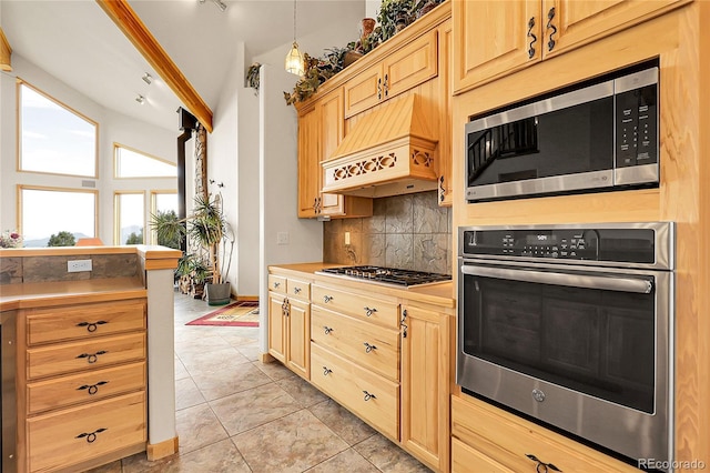 13954 Pine Country Ln, Conifer, CO 80433 - kitchen with appliances with stainless steel finishes, decorative backsplash, custom exhaust hood, light brown cabinets, and light tile patterned floors