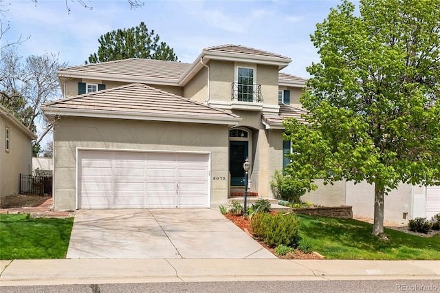 traditional home featuring a tiled roof, an attached garage, driveway, and stucco siding