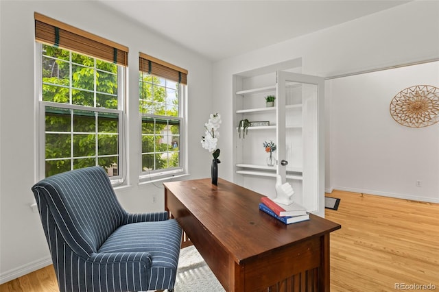 office area with light wood-style floors and baseboards