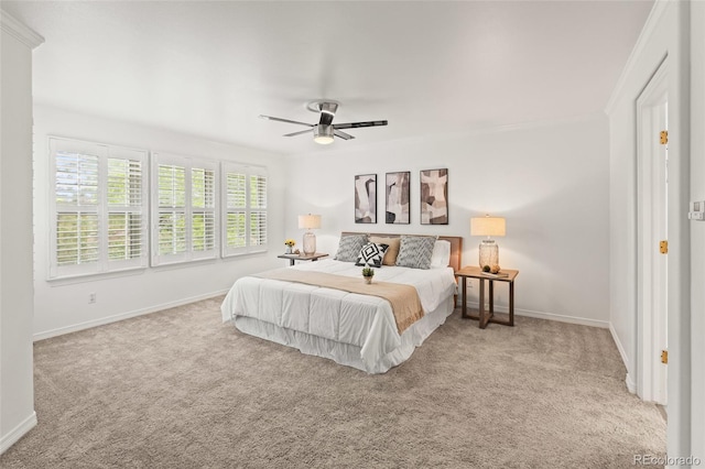 carpeted bedroom with baseboards, ceiling fan, and crown molding