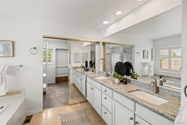 full bathroom with healthy amount of natural light, double vanity, a shower stall, a bath, and recessed lighting