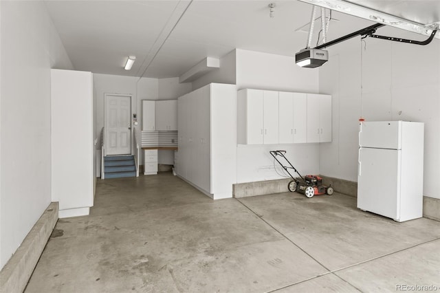garage with freestanding refrigerator and a garage door opener