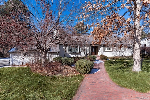 view of property hidden behind natural elements with a front yard