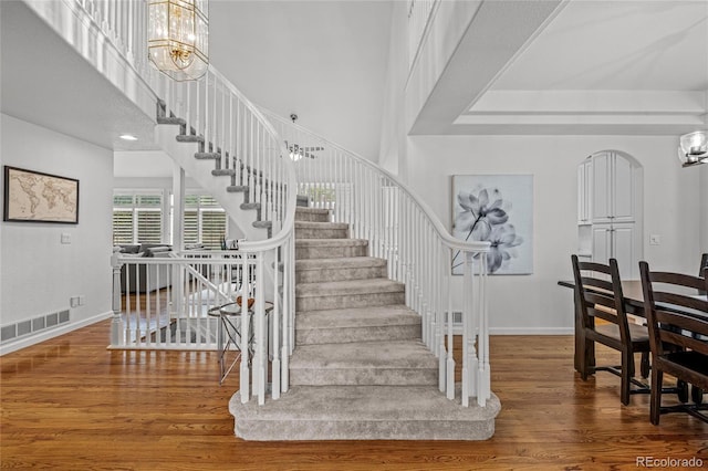16862 W 65th Cir, Arvada, CO 80007 - stairs with a chandelier, wood finished floors, and a towering ceiling